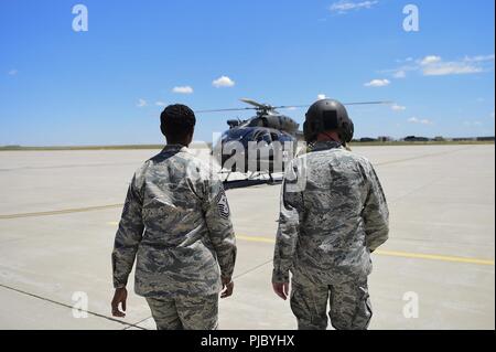 Us Air Force Chief Master Sgt. Tamar Dennis, 460Th Space Wing eingehenden Befehl Chief, Links, und Oberst Troy Endicott, 460Th Space Wing Commander, rechts, gehen Sie in Richtung UH-72A Lakota Hubschrauber für Ihre Incentive Flug Juli 13, 2018, Buckley Air Force Base, Colorado. Dennis und Endicott traf mit US-Armee Oberstleutnant Kenneth J. Walsh, Colorado Army National Guard Army Aviation Support Commander, über Ihre mission Fähigkeiten zu erlernen. Stockfoto