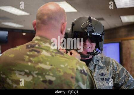 Us Air Force Colonel Troy Endicott, 460Th Space Wing Commander, ist mit dem Setzen auf einem Flug Helm durch die US-Armee Oberstleutnant Kenneth J. Walsh, Colorado Army National Guard Army Aviation Support Commander, 13. Juli 2018 unterstützte, auf Buckley Air Force Base, Colorado. Endicott erhielt eine Mission von Walsh vor über Base auf UH-72A Lakota Hubschrauber geflogen. Stockfoto