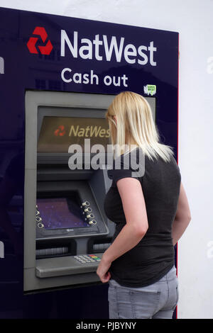 Zurück Blick auf eine junge Frau mit einem Nat West ATM im Dorf Bawtry Stockfoto