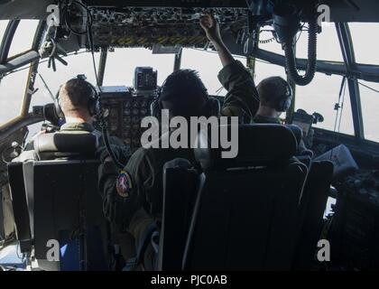 Piloten, Maj. Kevin Eikleberry (links) und 1. Lt. Zac Smith (rechts) und Flugingenieur, Tech. Sgt. Stephanie Tigner der 118 Airlift Squadron der C-130 H Flugzeuge fliegen auf dem Weg zum Fort McCoy, Wis., 18. Juli 2018, im Rahmen einer simulierten Katastrophenhilfe Mission während der PATRIOT Nord 18. PATRIOT Nord 18 ist ein jährlicher Gemeinsamer Übung, dass Tests der Interoperabilität der militärischen und zivilen Einrichtungen. (Air National Guard Stockfoto