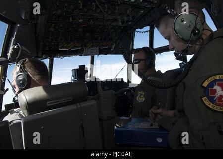 Piloten, Maj. Kevin Eikleberry (links) und 1. Lt. Zac Smith (rechts) und Flugingenieur, Tech. Sgt. Stephanie Tigner der 118 Airlift Squadron der C-130 H Flugzeuge fliegen auf dem Weg zum Fort McCoy, Wis., 18. Juli 2018, im Rahmen einer simulierten Katastrophenhilfe Mission während der PATRIOT Nord 18. PATRIOT Nord 18 ist ein jährlicher Gemeinsamer Übung, dass Tests der Interoperabilität der militärischen und zivilen Einrichtungen. (Air National Guard Stockfoto