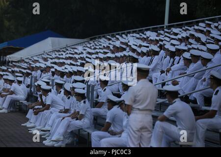 Midshipmen in Plebe Sommer teilnehmenden beobachten eine Schlacht Farbe Zeremonie an der United States Naval Academy, Annapolis, MD., 19. Juli 2018. Plebe Sommer ist eine Ausbildung, die Übergänge, die Zivilbevölkerung zu Midshipmen, und ist eine Voraussetzung für alle ankommenden Neulingen der USNA. Die jährliche Schlacht Farbe Zeremonie gibt die Midshipmen die Möglichkeit, die Beziehung zwischen der Navy und Marine Corps zu erleben. Stockfoto