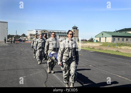 Us Air National Guard Mitglieder aus verschiedenen Einheiten, zivile Feuerwehr und Rettungsdienst arbeiten zusammen, um Air medevac Training auf der C-130 Hercules bei PATRIOT Nord 18 am Fort McCoy, Wis., 18. Juli 2018 durchzuführen. PATRIOT ist ein inländischer Betrieb Disaster Response Training durch die National Guard Einheiten arbeiten mit Bundes-, Landes- und lokale Emergency Management Agenturen und Ersthelfer durchgeführt. Stockfoto