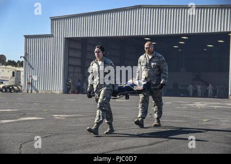 Us Air National Guard Mitglieder aus verschiedenen Einheiten, zivile Feuerwehr und Rettungsdienst arbeiten zusammen, um Air medevac Training auf der C-130 Hercules bei PATRIOT Nord 18 am Fort McCoy, Wis., 18. Juli 2018 durchzuführen. PATRIOT ist ein inländischer Betrieb Disaster Response Training durch die National Guard Einheiten arbeiten mit Bundes-, Landes- und lokale Emergency Management Agenturen und Ersthelfer durchgeführt. Stockfoto