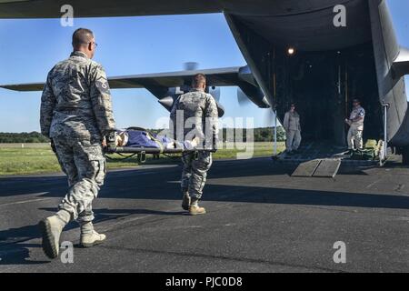 Us Air National Guard Mitglieder aus verschiedenen Einheiten, zivile Feuerwehr und Rettungsdienst arbeiten zusammen, um Air medevac Training auf der C-130 Hercules bei PATRIOT Nord 18 am Fort McCoy, Wis., 18. Juli 2018 durchzuführen. PATRIOT ist ein inländischer Betrieb Disaster Response Training durch die National Guard Einheiten arbeiten mit Bundes-, Landes- und lokale Emergency Management Agenturen und Ersthelfer durchgeführt. Stockfoto