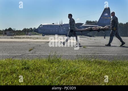 Us Air National Guard Mitglieder aus verschiedenen Einheiten, zivile Feuerwehr und Rettungsdienst arbeiten zusammen, um Air medevac Training auf der C-130 Hercules bei PATRIOT Nord 18 am Fort McCoy, Wis., 18. Juli 2018 durchzuführen. PATRIOT ist ein inländischer Betrieb Disaster Response Training durch die National Guard Einheiten arbeiten mit Bundes-, Landes- und lokale Emergency Management Agenturen und Ersthelfer durchgeführt. Stockfoto