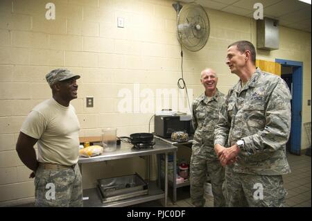 Us Air Force Colonel William A. Foster, stellvertretender Direktor von Manpower, Personal und Dienstleistungen in der Air Force Reserve Command und dem AFRC Innovative Bereitschaft, Manager, Maj. Michael McDonald, Besuch mit Tech. Sgt. Friedrich Carter, Lakeland, Fla., Mitglied der 927Th der Air Force Reserve Air Refuelling Flügel, MacDill Air Force Base, Fla., wer kocht Mahlzeiten für das Personal in Millen, Ga, 14. Juli 2018 liegt, während der Osten Central Georgia Innovative Readiness Training. Das IRT bietet praktische, reale Ausbildung Bereitschaft und Interoperabilität für Service Mitglieder in komplexen Kontingenz zu verbessern. Stockfoto