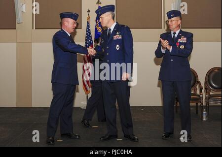 Kol. Troy Endicott, 460Th Space Wing Commander, Links, schüttelt die Hand von Oberst Trevor Wentlandt, 460Th Mission Support Gruppe eingehenden Commander, bei einem Wechsel des Befehls Zeremonie Juli 12, 2018, Buckley Air Force Base, Colorado. Eine Änderung der Befehl ist eine militärische Tradition, die eine formelle Übertragung der Autorität von einem Kommandanten zum anderen. Stockfoto