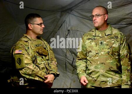 In diesem Bild, von der U.S. Army Reserve, Maj. David Melendez, Bataillon Executive Officer für die 391 Techniker Bataillon, Teil der 420th Engineer Brigade freigegeben, Gespräche mit Command Sgt. Maj. Ted Copeland, command Sgt. maj. für die US-Armee finden, während der Fluss Angriff 2018 am Fort Chaffee, Arkansas, 18. Juli 2018. Die Ausübung betont die Krieger und Ingenieur Fähigkeiten der Truppe, da sie zwei Wochen Training in Waffen Vertrautheit, Sicherheit und nassen Spalt Kreuzung in einem taktischen Umfeld. Stockfoto