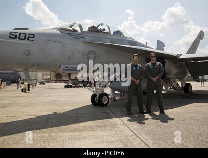 Navy Leutnant Frank 'Sweet Francis' Ascioti, Electronic Attack Squadron 130 Naval Flight Officer und Navy Leutnant Troy "chump" Horrigan, VAQ-130 Pilot, posieren für ein Foto an die 2018 grossen New England Air und Space Show Juli 14, 2018, an Westover Air Reserve Base, Chicopee, Massachusetts. Beide Beamten hatten die Luft Show besucht haben, beim aufwachsen und sagte, dass es ein Traum wurde wahr es mit ihren EA-18G Growler. Stockfoto