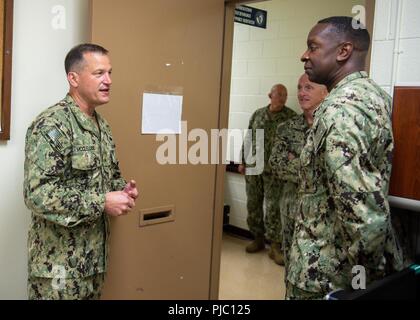 NAVAL STATION GUAM (Jan. 18, 2018) Hintere Adm. Troy M. McClelland, Stellvertreter für den Schiffbau auf Kraft, Marine Expeditionary Combat Command, grüßt Segler und Personal von Commander, Task Force (CTF) 75 während einer Tour. Commander, Task Force (CTF) 75, die primäre Expeditionary task force verantwortlich für die Planung und Ausführung der Küstengebiete Riverine operations, Beseitigung von Explosivstoffen, tauchen Engineering und Bau und Unterwasser Bau in den USA 7 Flotte Verantwortungsbereich. Stockfoto