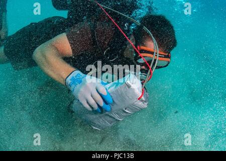 MAMALA BAY, Hawaii (19 Juli 2018) Konstruktionsmechaniker 3. Klasse Lucas Jackson, Underwater Bau Team (UCT) 2, Orte einen Sprengsatz auf dem Meeresboden während Underwater Demolition Ausbildung in Mamala Bay während des Pacific Rim (Rimpac) Übung, Juli 19 zugeordnet. 25 Nationen, 46 Schiffe, 5 U-Boote, über 200 Flugzeuge und 25.000 Angestellte beteiligen sich an Rimpac vom 27. Juni bis 2. August in und um die hawaiischen Inseln und Südkalifornien. Die weltweit größte internationale maritime Übung RIMPAC bietet eine einzigartige Ausbildung während der Förderung und Stockfoto