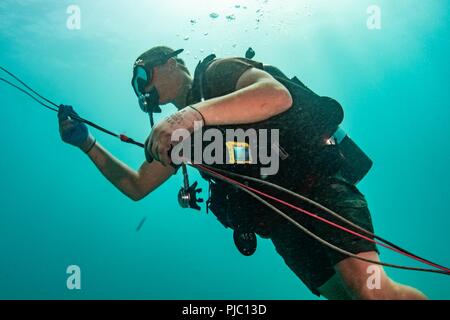 MAMALA BAY, Hawaii (19 Juli 2018) Konstruktionsmechaniker 3. Klasse Lucas Jackson, Underwater Bau Team (UCT) 2, Orte einen Sprengsatz auf dem Meeresboden während Underwater Demolition Ausbildung in Mamala Bay während des Pacific Rim (Rimpac) Übung, Juli 19 zugeordnet. 25 Nationen, 46 Schiffe, 5 U-Boote, über 200 Flugzeuge und 25.000 Angestellte beteiligen sich an Rimpac vom 27. Juni bis 2. August in und um die hawaiischen Inseln und Südkalifornien. Die weltweit größte internationale maritime Übung RIMPAC bietet eine einzigartige Ausbildung während der Förderung und Stockfoto