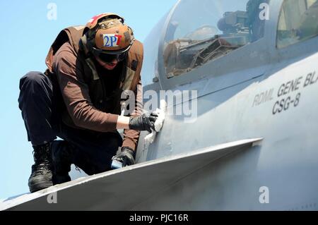 Atlantik (17. Juli 2018) Die Aviation Machinist Mate Airman Redfield Shaw Wischtücher unten ein F/A-18F Super Hornet auf dem Flugdeck an Bord der Nimitz-Klasse Flugzeugträger USS Harry S. Truman (CVN 75). Harry S. Truman ist derzeit als Teil eines laufenden Rotation der US-Streitkräfte unterstützen Maritime Security Operations in internationalen Gewässern rund um den Globus eingesetzt. Stockfoto