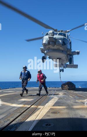 Philippinischen MEER (20 Juli 2018) Segler, die ticonderoga-Klasse geführte-missile Cruiser USS Antietam (CG54) Ausstieg nach Sicherung der Ladung an einem MH-60R Sea Hawk Hubschrauber, der "Warlords" von Hubschrauber Maritime Strike Squadron (HSM) 51 zugeordnet, wie es schwebt über dem Schiff Flight Deck. Antietam freut - in den USA 7 Flotte Bereich für Maßnahmen zur Erhöhung der Sicherheit und Stabilität in der indopazifischen Region bereitgestellt. Stockfoto