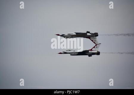 Zwei US Air Force Thunderbirds ein gespiegeltes Pass bei der großen New England Air Show, 14. Juli 2018 durchzuführen, muss der Westover Air Reserve Base in Chicopee, Mass dieser Trick gemeint ist, als ob die beiden Flugzeuge sind ein Spiegelbild des anderen, wie sie Fliegen zu erscheinen. Stockfoto