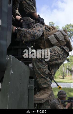 Ein US-Marine mit II Marine Expeditionary Force Support Battalion, II MEF Information Group, bereitet sich auf einen Konvoi während ein Bataillon Feldübung in Camp Lejeune, N.C., 17. Juli 2018 abzuweichen. Die Schulung wurde durchgeführt, um die Marines' Fähigkeit, kampftaktik in einer Bekämpfung der Umgebung durchführen und die Bereitschaft zu verbessern. Stockfoto