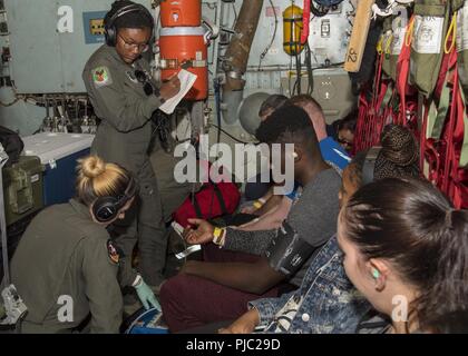 Senior Airman Britney Orr, ein aeromedical evacuation Techniker mit dem 156 Aeromedical Squadron in Charlotte, North Carolina, und Tech. Sgt. Erin Morit, einem aeromedical evacuation Techniker mit dem 142 Aeromedical Geschwader, das Neue Schloss Air National Guard Base, Virginia, überprüfen Sie die Vitalparameter des Patienten auf einer C-130 Hercules im Flug über den Mittleren Westen der USA im Rahmen des Patriot Nord 18 Übung 18. Juli 2018. Patriot ist ein inländischer Betrieb Disaster Response Training durch die National Guard Einheiten arbeiten mit Bundes-, Landes- und lokale Emergency Management Agenturen und Ersthelfer durchgeführt Stockfoto