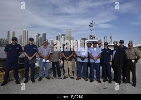 Kapitän Megan Dean, der Kommandant der Küstenwache Sektor Miami, steht mit den Besatzungen der Schlepper Miami, Jean Ruth und Peggy Ann nach Ausstellen der Sie Zertifikate der Inspektion im Hafen von Miami, 20. Juli 2018. Die Zertifikate der Inspektion auf den Schlepper Peggy Ann, Jean Ruth und Miami ausgestellt sind das Ergebnis von Jahren der Arbeit zwischen Ihnen und der Küstenwache zu schaffen Sicherheit Vorschriften für die Inspektion Normen und Safety Management Systems von Abschleppen von Schiffen. Küstenwache Stockfoto