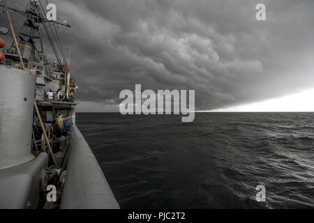 Atlantik (17. Juli 2018) Die Crew der USNS Erfassen (T-ARS 51) zusehen, wie ein Sturm Ansätze vor der Küste von Long Island, New York. Mobile Tauchen und Bergung Einheit 2 Matrosen an Bord fassen Sie mit der Geschichte und das Erbe Befehl Personal Inspektionen von San Diego und auch in einer Kranzniederlegung Festakt zum 100-jährigen Jubiläum seiner Versenkung zu gedenken teilnehmen, ehrt die sechs US-Marine Seeleute, die auf dem Schiff starb. Stockfoto