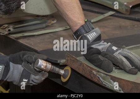 Us-Armee Pfc. Chris Gagne, Alpha Truppe, 1st Squadron, 172Nd Infanterie Regiment (Berg), Vermont National Guard, schleift den Lack von der Schmutzfänger eines Light Medium Tactical Vehicle (LMTV) bei der kombinierten Support Wartung Shop Automobil- und Baunebenberufe im Camp Johnson in Colchester, Vermont, Juli 19. Regelmäßige Wartung und übergeordneten Reparaturen sind Teil dieser Lkw Mission bereit zu halten. Stockfoto