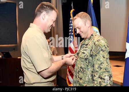 Us-Marine Electronics Technician (U-Boot-Radio) Senior Chief Robert McNeal, US Strategic Command (USSTRATCOM) Navy Element älterer Soldat Führer, fördert Intelligenz Specialist 1. Klasse William Langston während einer Navy Element alle Hände an USSTRATCOM's Theater auf der Offutt Air Force Base, Neb., 19. Juli 2018. Langston war der einzige USSTRATCOM Soldaten Sailor für Fortschritt als Teil des verdienstvollen Förderprogramm ausgewählt. USSTRATCOM hat globale Verantwortung durch die Unified Command Plans zugeordnet, dass der strategischen Abschreckung, nukleare Operationen, Space Operations, Jo gehören Stockfoto