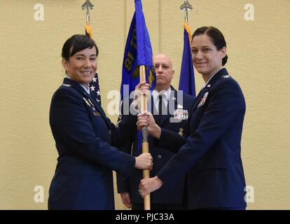 Us Air Force Colonel Debra Vogt, 81st Training Wing Commander, übergibt der 81st Mission Support Group guidon zu oberst Marcia Quigley, 81St MSG Commander, während der 81St MSG Ändern des Befehls Zeremonie in der Bay Breeze Veranstaltungszentrum am Keesler Air Force Base, Ohio, 19. Juli 2018. Die Verabschiedung des Guidon handelt es sich um einen zeremoniellen Symbol für den Austausch von Befehl von Commander zu einem anderen. Stockfoto