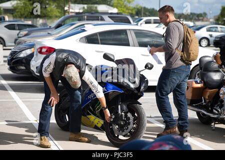 Us Marine Corps Chief Warrant Officer 2 Michael Dilling und Lance Cpl. Harry Stecher mit Sitz und Hauptverwaltung Squadron eine Sicherheitsprüfung durchführen, bevor das Motorrad fahren für Sicherheit bei Marine Corps Air Station Cherry Point, N.C., Juli 6, 2018. H&HS Gastgeber der Veranstaltung Sicherheit zu fördern und die richtige Reitschule Etikette. Dilling ist die Basis Telefon Officer und Stecher ist ein Großteil der Spezialist. Stockfoto