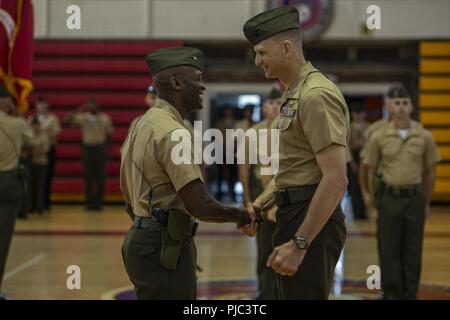 Us Marine Corps Oberst James A. Ryans, Links, den entgegenkommenden kommandierender Offizier der Hauptsitz Bataillon (HQBN), 2nd Marine Division, und Oberst Samuel C. Kochen, rechts, die Ausgehende kommandierender Offizier der HQBN, Hände schütteln bei einem Befehl Zeremonie am Goettge Memorial Field House in Camp Lejeune, N.C., 13. Juli 2018. Während der Zeremonie, Koch das Kommando über die Einheit zu Ryans aufgegeben. Stockfoto