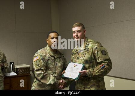 Command Sgt. Maj. Michael L. Berry, Kommandant der US-Army Drill Sergeant Akademie, stellt ausgehende Chief Instructor, 1 Sgt. Justin D. Richardson mit einem Meritorious Service Medal für seine Hingabe an USADSA. 1. Sgt. Richardson verändert die Verantwortung für die Alpha Company mit Sgt. 1. Klasse Chauncey J. Raiden, die eingehenden Chief Instructor, während ein Wechsel der Verantwortung Zeremonie am USADSA, 12. Juli 2018 statt. Stockfoto