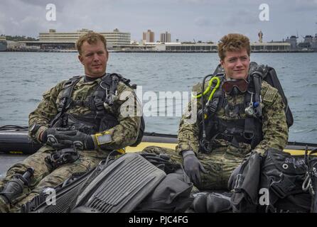 JOINT BASE Pearl Harbor - HICKAM, Hawaii (13. Juli 2018) - Erbauer der 1. Klasse Lance Fairchild, Links, und Marine Diver 2. Klasse Casey Ras, sowohl zur Marine Service Engineering und Expeditionary Warfare Center zugeordnet, Vorbereitung zum Tauchen die USS Arizona Memorial zu seinen Anker Punkte während der Pacific Rim (Rimpac) Übung, Juli 13 prüfen. 25 Nationen, 46 Schiffe, 5 U-Boote, über 200 Flugzeuge, und 25.000 Mitarbeiter beteiligen sich an Rimpac vom 27. Juni bis 2. August in und um die hawaiischen Inseln und Südkalifornien. Die weltweit größte internationale maritime Übung RIMPAC pro Stockfoto