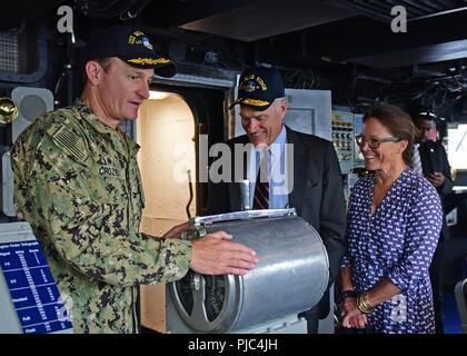 YOKOSUKA, Japan (12. Juli 2018) Kapitän Brett E. Crozier, kommandierender Offizier der US-7 Flotte Flaggschiff USS Blue Ridge LCC (19), zeigt der Sekretär der Marine Richard V. Spencer und seine Frau, Polly Spencer, die Brücke bei einem Rundgang durch das Schiff. Spencer met mit Führung und sprach mit der Crew. Blue Ridge und ihre Crew haben jetzt eine abschließende Pflege und Training Phase in der Vorbereitung voll für den Einsatz in der Mission werden eingegeben. Stockfoto