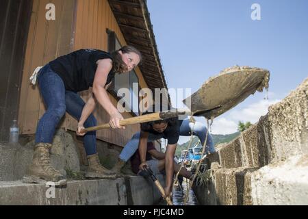 Us Marine Corps Lance Cpl. Alaina Harmon, ein Großteil der Spezialist mit Marine Wing Support Squadron 171, Schaufeln Schlamm und Schmutz während eines freiwilligen Veranstaltung in Shimo-nakazone, Shuto in Iwkauni Stadt, Japan, 14. Juli 2018. Die freiwillige Veranstaltung, die von der Marine Corps Community Services Single Marine Programm organisiert, sofern Service Mitglieder mit der Gelegenheit, den lokalen japanischen Bewohner sauber und nach der Wiederherstellung wurde durch Starkregen überflutet. Stockfoto