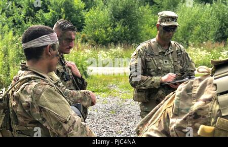 Yavoriv, Ukraine-Klasse 703-2018 Basic Führung Kurs von 7th Army Training Befehl nicht angewiesen, Unteroffizieren während ein Feld Training am Yavoriv Combat Training Center (CTC) am 11. Juli. 40 Soldaten der 27 Infantry Brigade Combat Team (Vorwärts) Teil im Kurs und, wie hier zu sehen Truppführer Sgt. Chris Cormack von Penfield, NY, Schriftsatz sein Lehrer auf seine Leistung während einer Aktion. Stockfoto