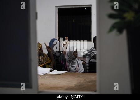 Djiboutian Studenten eifrig sind, eine Frage aus der US-Armee die zivilen Angelegenheiten Bataillon Ausbilder zu beantworten, während Englisch Klasse in Tadjourah, Dschibuti, 10. Juli 2018. Die zivilen Angelegenheiten Team führt Englisch Diskussion Gruppen während des Combined Joint Operations, lokale Beziehungen in der Region zu stärken und gleichzeitig Möglichkeiten für Kinder, ihr Wissen und ihre Kenntnisse in der englischen Sprache zu erweitern. Stockfoto