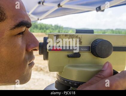 Us Air Force Reserve Staff Sgt. Eugene Murray III, eine Engineering Assistant mit den 159 Naval Air Station gemeinsame Reserve Base New Orleans, Louisiana, sieht vor seinem Auto Level während der Hebung Schüsse von unbekannten Punkten, um zu bestimmen, wo konkrete Sturm Wasserleitungen liegen wird, während der ersten Phase der Bau von Camp Kamassa in Crystal Springs, Mississippi, 16. Juli 2018. Camp Kamassa werden die Mitgliedstaaten erste vollständig behindertengerecht, ganzjährig Camp für Kinder und Erwachsene mit besonderen Bedürfnissen, die auf 326 Hektar von der Abteilung für Innovative's Defence R spearheaded gebaut wird Stockfoto