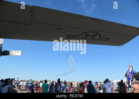 Ein warmer Tag für Minnesotans, den Teilnehmern an der Duluth 2018 Air Show Schatten unter einem Flügel der Minnesota Air National Guard C-130 Hercules während einer Performance der United States Air Force Thunderbirds am Samstag, 7. Juli 2018. Die 2018 Duluth Air Show die United States Air Force Thunderbirds zusammen mit einem Wirt anderer Darsteller auf dem Duluth Flughafen auf Juli 7-8. Stockfoto