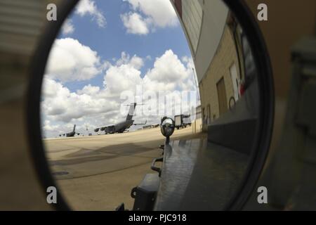 Mitglieder der 145 Aircraft Maintenance Squadron (AMXS) bereiten Sie abschleppen a bis C-17 Globemaster III Flugzeuge auf der North Carolina Air National Guard Base, Charlotte Douglas International Airport, 24. Juli 2018. Da die Flugzeuge Umbau im April, der 145 AMXS arbeitet Wartungspersonal mit einem Ziel, sie voll qualifizierte zu trainieren. Stockfoto