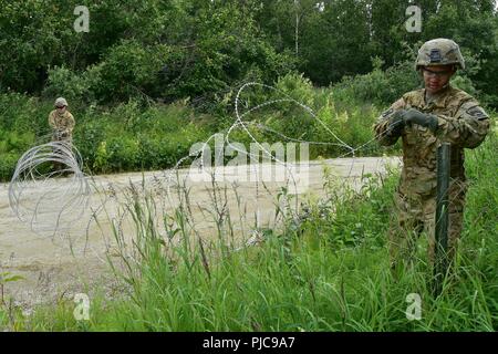 Spc. Kevin Johnson und SPC. Zachary Leavitt Einrichten concertine Kabel Hindernisse um E Unternehmen, 1 Battalion, 52nd Aviation Vorwärts Bereich Tanken Punkt an Firebird Angriff Landeplatz im Yukon Training Bereich Juli 19. (Armee Foto/John pennell) Stockfoto