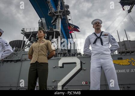 Freigegeben PAZIFISCHER OZEAN (10 Juli 2018) - Segler zugeordnet Wasp-Klasse amphibisches Schiff USS Essex (LL 2) und Marines zugeordnet. bis 13 Marine Expeditionary Unit (MEU) die Schienen Mann auf dem Flight Deck während der Abfahrt Marinestützpunkt San Diego während einer planmäßigen Einsatz von Essex Amphibious Ready Group (ARG) und 13 MEU. Das Essex ARG/MEU Team ist ein stark, flexibel, reaktionsschnell und gleichbleibende Kraft in der Lage, Manöver Kriegsführung in allen Domänen; es ist ausgestattet und skalierbar auf jede Krise von der humanitären Hilfe und Katastrophenhilfe zu Blindbewerbungen zu reagieren. Stockfoto
