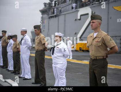 Freigegeben PAZIFISCHER OZEAN (10 Juli 2018) - Segler zugeordnet Wasp-Klasse amphibisches Schiff USS Essex (LL 2) und Marines zugeordnet. bis 13 Marine Expeditionary Unit (MEU) die Schienen Mann auf dem Flight Deck während der Abfahrt Marinestützpunkt San Diego während einer planmäßigen Einsatz von Essex Amphibious Ready Group (ARG) und 13 MEU. Das Essex ARG/MEU Team ist ein stark, flexibel, reaktionsschnell und gleichbleibende Kraft in der Lage, Manöver Kriegsführung in allen Domänen; es ist ausgestattet und skalierbar auf jede Krise von der humanitären Hilfe und Katastrophenhilfe zu Blindbewerbungen zu reagieren. Stockfoto