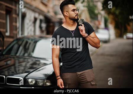 Super schönen hohen ararbian Bart Macho in Gläsern und schwarzes T-Shirt zu Fuß gegen das Geschäft. Stockfoto