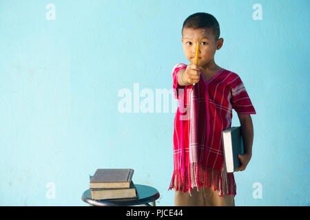 Little boy Holding in einem großen Buch auf einem hellblauen Hintergrund. Stockfoto