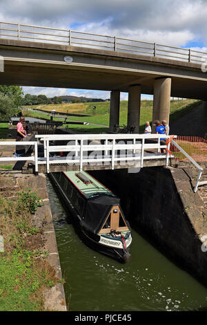 Die schmalen Boot Hollinhurst ist absteigend die Barrowford Flug der Schleusen am Leeds und Liverpool Canal in East Lancashire am 30.7.18. Stockfoto