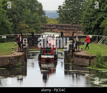 Die schmalen Boot "REIHERENTE" ist die Eingabe der 2. Sperre eines langen Flug von Sperren der Abstieg zu beginnen auf dem Leeds und Liverpool Canal in Wigan. Stockfoto