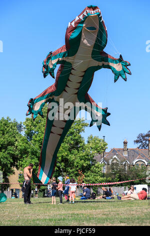 Brighton Drachenflieger fliegen ihre riesigen Krokodil in Streatham gemeinsame Kite Tag kite Festival, Streatham, London, UK Stockfoto