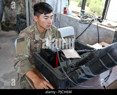 Armee SPC. Jeffery Vang, Anchorage, Alaska Native und Teamleiter zu Alpha Company, 2nd Battalion, 5th Cavalry Regiment, 1st Armored Brigade Combat Team, 1.Kavallerie Division, steuert die Auswahl Zielsystem während einer schießwesen bei Novo Selo, Bulgarien, 19. Juli 2018. Dieses Targeting System ermöglicht Ziele für Bradley zu Popup Kampf Fahrzeugbesatzungen zu engagieren und verfolgt automatisch ihre Kerben. Stockfoto