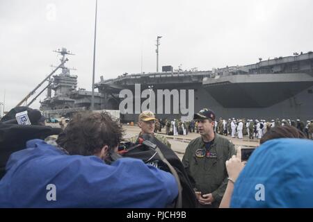 NORFOLK (Juli 21, 2018) - Kapitän Nick Dienna, Kommandierender Offizier USS Harry S. Truman (CVN 75), spricht mit den Medien auf die Pier nach Truman's Rückkehr von der Bereitstellung. Die USS Harry S. Truman Strike Group hat zur Unterstützung der Maritime Security Operations und Theater Sicherheit Zusammenarbeit in den USA am 5. und 6 Flotte Verantwortungsbereich eingesetzt. Mit Harry S. Truman als Flaggschiff, Bereitstellung Streik Vermögenswerte des Konzerns gehören Personal, Schiffe und Flugzeuge von Carrier Strike Group Acht (CSG 8), Zerstörer Geschwaders zwei Acht (DESRON 28) und Carrier Air Wing (CVW-1). Stockfoto