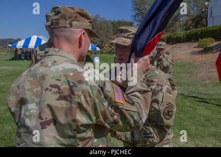 FORT Hunter Liggett, CALIF. - Armee-reserve Brig. Gen. Michael D. Roache, eingehende Kommandant der Pacific Division, 84th Ausbildung erhält den Befehl, die Farben der Division von Generalmajor A. Ray Lizenzgebühren, Kommandierender General des 84th Ausbildung Befehl während der Änderung der Befehl Zeremonie, auf Fort Hunter Liggett, 22. Juli 2018 statt. Die Änderung des Befehls Zeremonie erinnert an roache als stellvertretender Kommandeur der Pacific Division, 84th Ausbildung Befehl, von Brig. Gen. Brently F. Weiß. Stockfoto