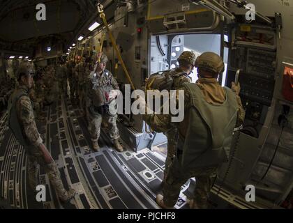 JOINT BASE Pearl Harbor - HICKAM, Hawaii (Juli 17, 2018) - eine jumpmaster steht in der Tür eines C-17 Globemaster III wartet der Drop Zone zu nähern, während die Republik Korea Navy Special Warfare Flottille Höhen -- geringe Öffnung Jumper (links) fungiert als sekundäre jump Master als Teil eines statischen Linie airborne Training während der Rand des Pazifik (Rimpac) Übung, Juli 17. 25 Nationen, 46 Schiffe, 5 U-Boote, über 200 Flugzeuge und 25.000 Angestellte beteiligen sich an Rimpac vom 27. Juni bis 2. August in und um die hawaiischen Inseln und Südkalifornien. Die weltweit größte int Stockfoto